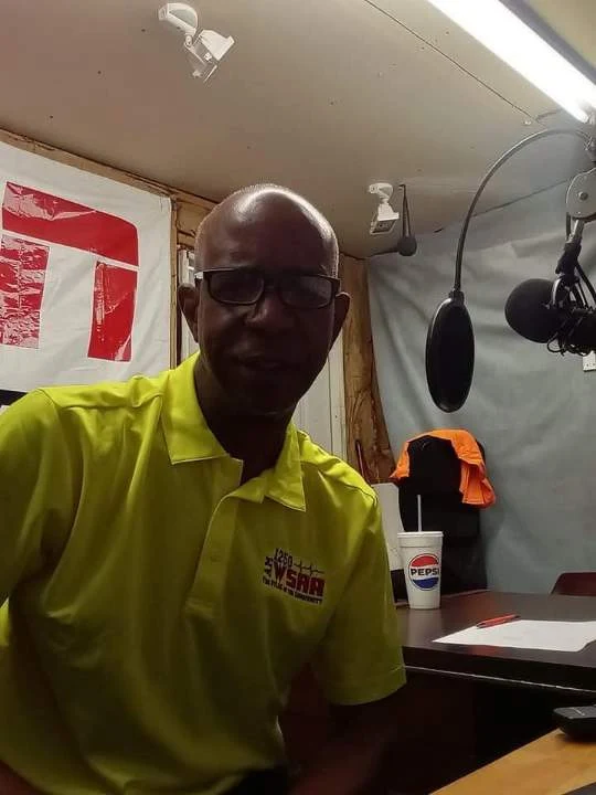 TCB in a yellow polo beside the microphone